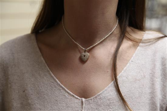 An early 20th century gold, ruby and split pearl set heart shaped pendant locket, pendant inc. bale 1in.